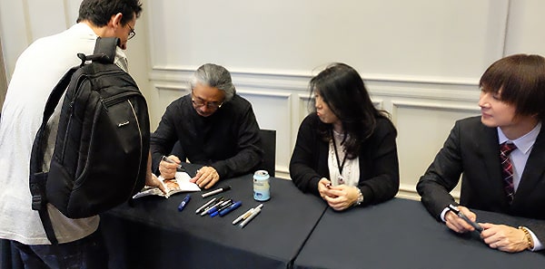 Eu pegando o autógrafo de Nobuo Uematsu, Yoko Shimomura e Yasunori Mitsuda